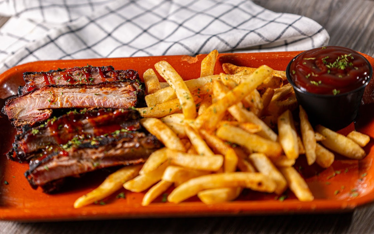 Grilled sliced meat, fries and dip on the side